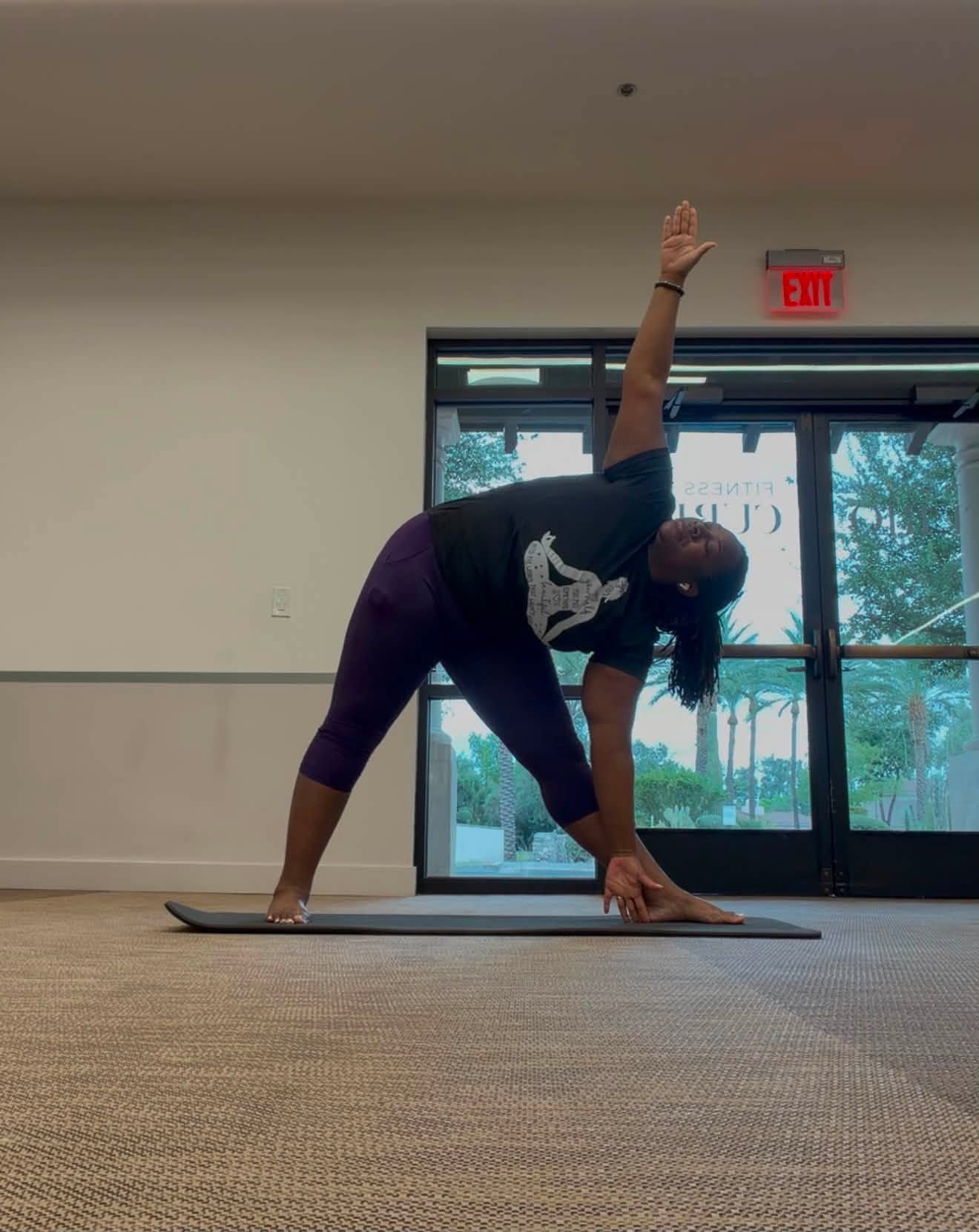 Quisha practicing triangle pose on a yoga mat